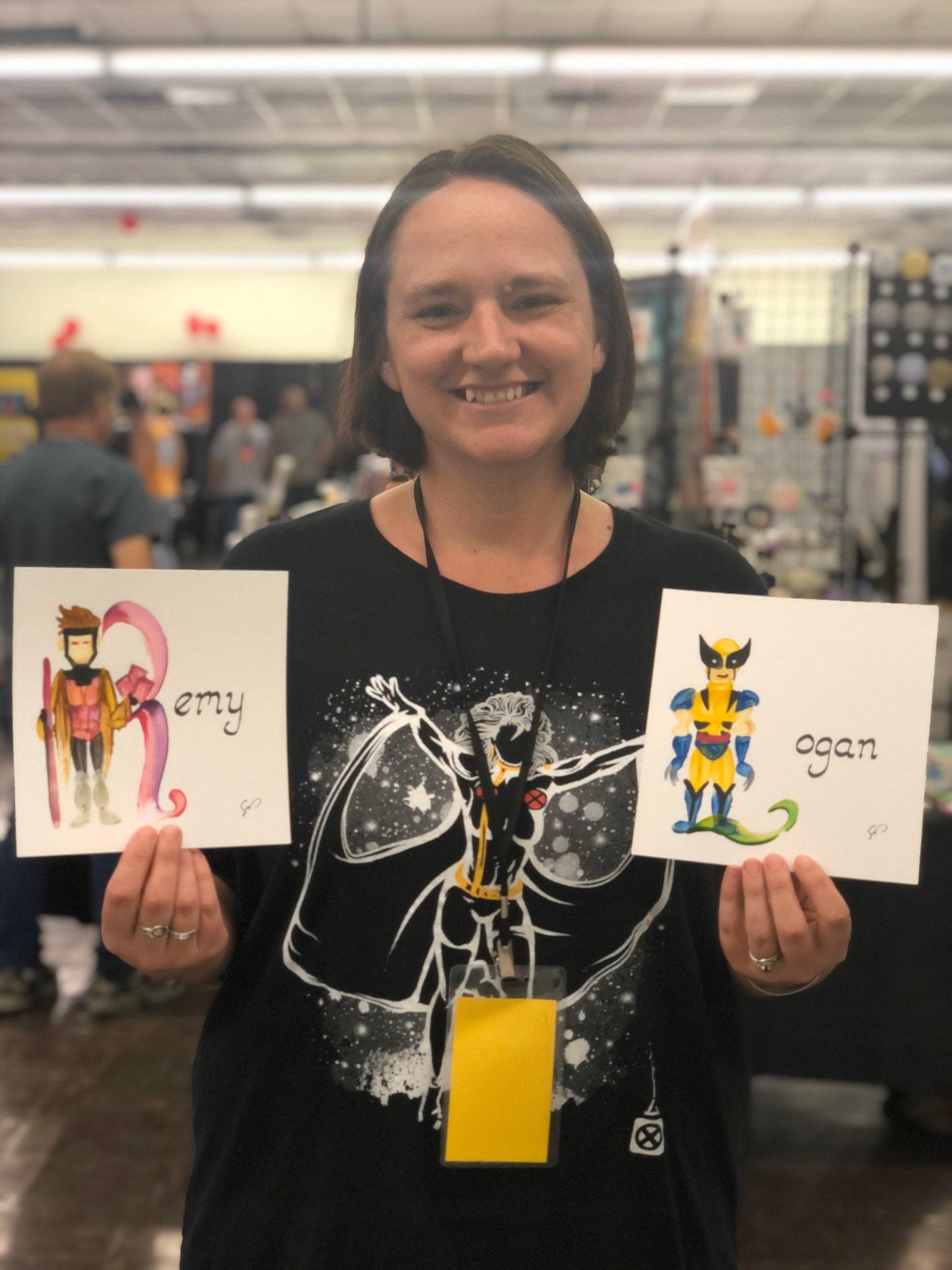 A very happy mama with two single painted character names featuring mutants with the names "Remy" and "Logan" taken at Bakersfield Comic Con